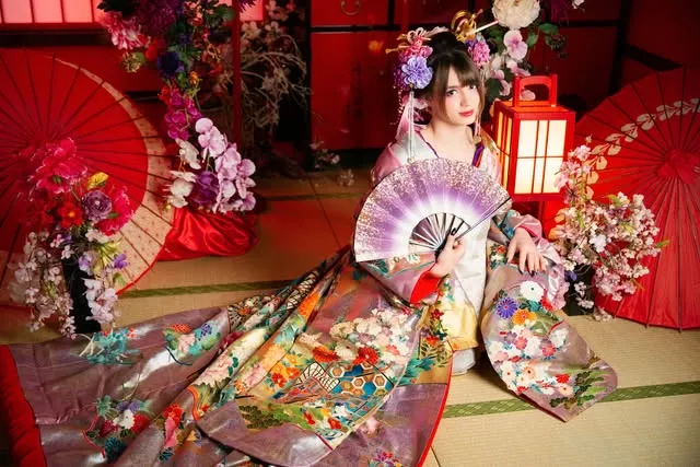 Natsumi en tenue japonaise, entourée de fleurs et d’ombrelles