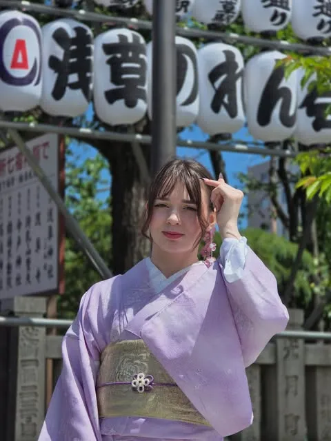 Natsumi en kimono mauve devant des lanternes au Japon